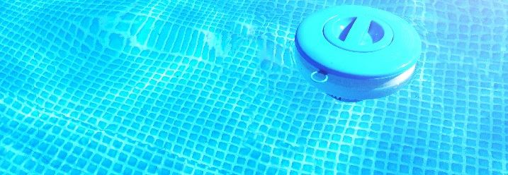 Ein Behälter für Chlortabletten schwimmt im Swimmingpool.